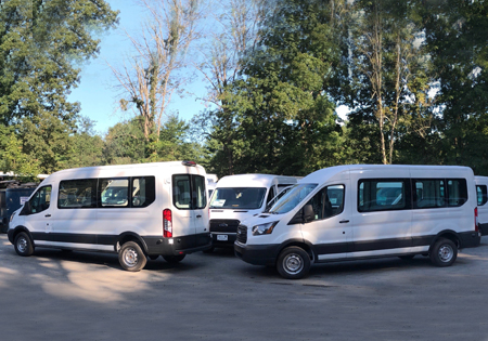 parking lot with several parked white vans