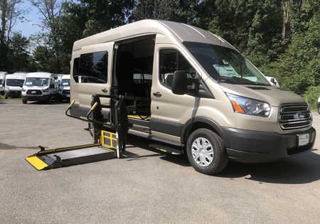 parked tan van with lowered black platform