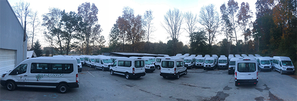 parking lot with parked white vans and white shed